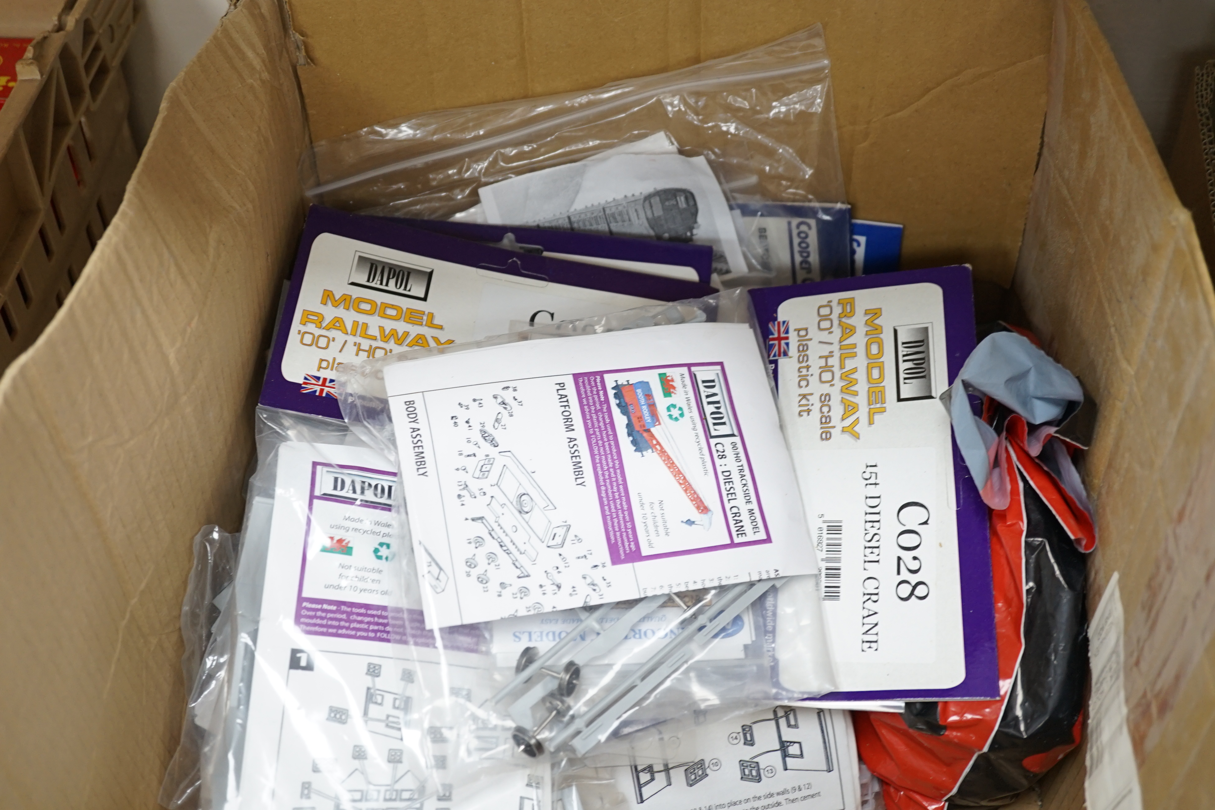 A collection of packeted white metal and plastic 00 gauge model railway kits by Dapol, 4mm Scale Vehicle kits R. Parker, etc. including diesel cranes, AEC lorries, LBSCR Stroudley 4-wheel coaches, trackside vehicles, etc